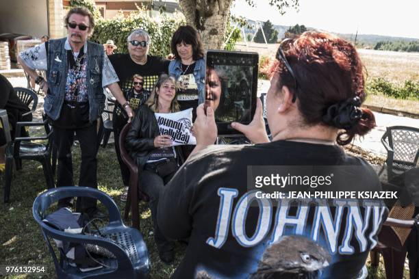 Woman takes a picture of a Johnny Hallyday look-alike during the inauguration of a statue of the late French rocker installed in the Southeastern...