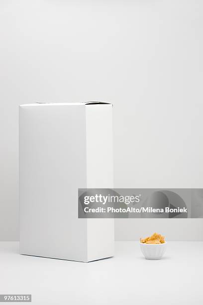 white cereal box and small bowl of cereal - cereal box stock-fotos und bilder