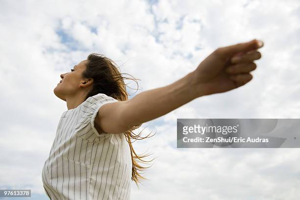 woman with arms outstretched, head back, enjoying fresh air - fresh air breathing stockfoto's en -beelden