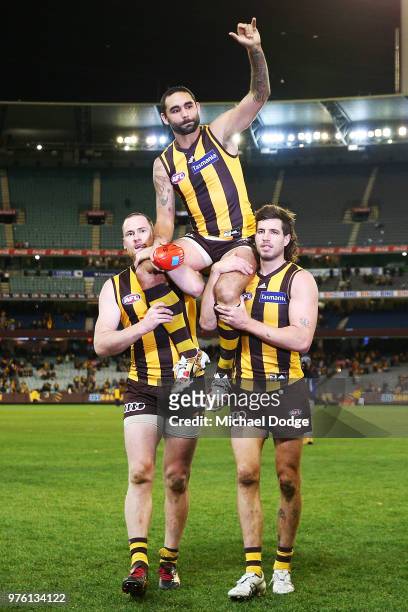 Shaun Burgoyne of the Hawks is carried off by Jarryd Roughead and Ben Stratton for his 350th match during the round 13 AFL match between the Hawthorn...