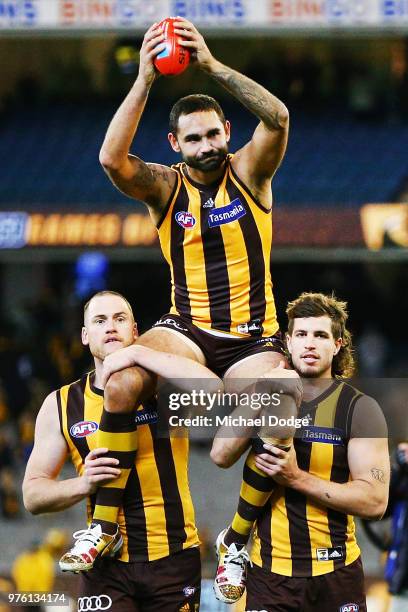 Shaun Burgoyne of the Hawks is carried off by Jarryd Roughead and Ben Stratton for his 350th match during the round 13 AFL match between the Hawthorn...