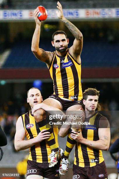 Shaun Burgoyne of the Hawks is carried off by Jarryd Roughead and Ben Stratton for his 350th match during the round 13 AFL match between the Hawthorn...