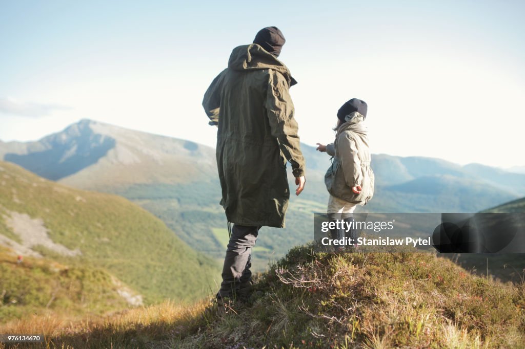 Father with daughter looking at view in mountains