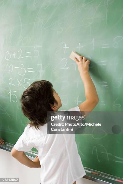 boy erasing classroom blackboard, rear view - tafelwischer stock-fotos und bilder