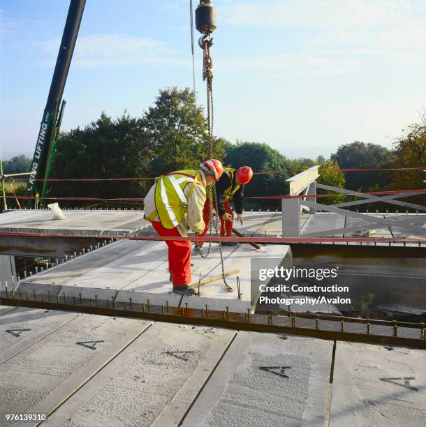 Installation of pre-fabricated concrete deck sections during construction of office block.