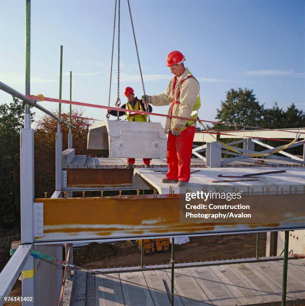 Placing of prefabricated concrete deck section on building.