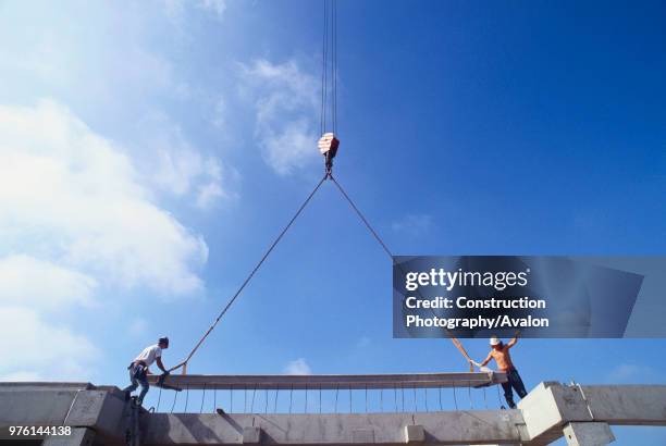 Placing of prefabricated concrete deck section on building.