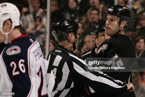 Ryan Getzlaf of the Anaheim Ducks is held off from going after Samuel Pahlsson of the Columbus Blue Jackets by a referee during the game on March 9,...