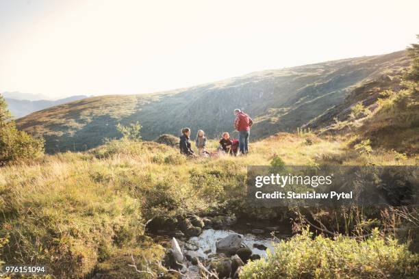 family with small kids taking break during trekking in mountains - family holiday europe stockfoto's en -beelden