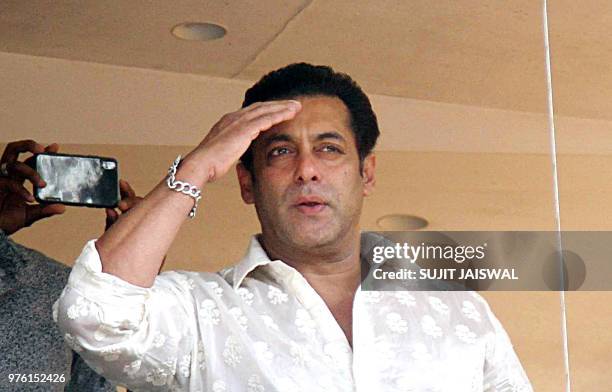 Indian Bollywood actor Salman Khan waves to his fans during Eid al Fitr from his residence in Mumbai on June 16, 2018. - Muslims around the world...