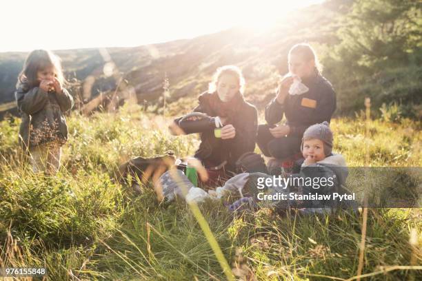 family enjoyng meal when trekking in mountains at sunset - familie wandern stock-fotos und bilder