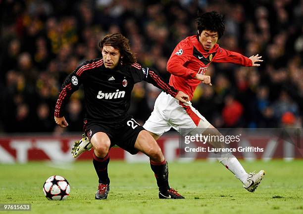 Andrea Pirlo of AC Milan is challenged by Ji-Sung Park of Manchester United during the UEFA Champions League First Knockout Round, second leg match...