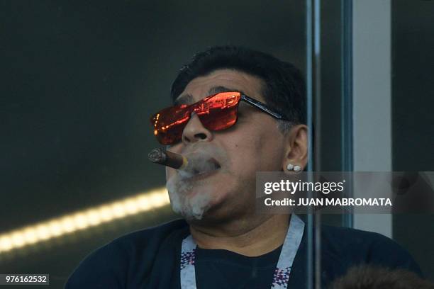 Argentina's football legend Diego Maradona smokes a cigare as he attends the Russia 2018 World Cup Group D football match between Argentina and...