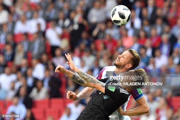 Argentina's midfielder Lucas Biglia heads the ball with Iceland's defender Kari Arnason during the Russia 2018 World Cup Group D football match...