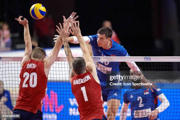 Serbia's Srecko Lisinac spikes the ball at USA's David Smith and USA's Matthew Anderson in game action during the Volleyball Nations League match...