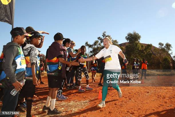 Olympic boxer Shelley Watts high fives other runners as she finishes the Uluru Relay Run as part of the National Deadly Fun Run Championships on June...