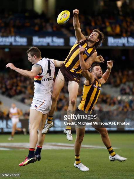Ben Stratton of the Hawks punches the ball from Josh Jenkins of the Crows during the 2018 AFL round 13 match between the Hawthorn Hawks and the...
