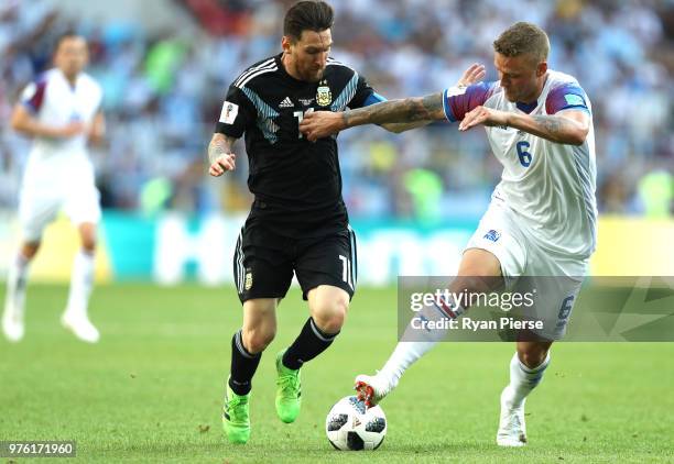 Lionel Messi of Argentina and Ragnar Sigurdsson of Iceland battle for possession during the 2018 FIFA World Cup Russia group D match between...