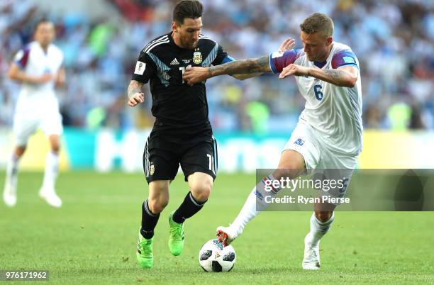 Lionel Messi of Argentina and Ragnar Sigurdsson of Iceland battle for possession during the 2018 FIFA World Cup Russia group D match between...