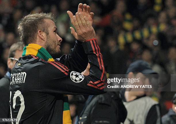 Milan's English midfielder David Beckham wears a green and gold scarvf after their UEFA Champions League round of 16, second leg football match...