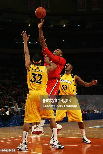 Sean Evans of the St. John's Red Storm goes to the hoop against Lazar Hayward and Jimmy Butler of the Marquette Golden Eagles during the second round...