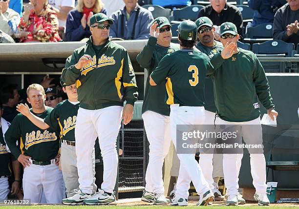 Manager Bob Geren and coach Curt Young of the Oakland Athletics congratulate Eric Chavez after he hit a 2 run home run against the Chicago White Sox...