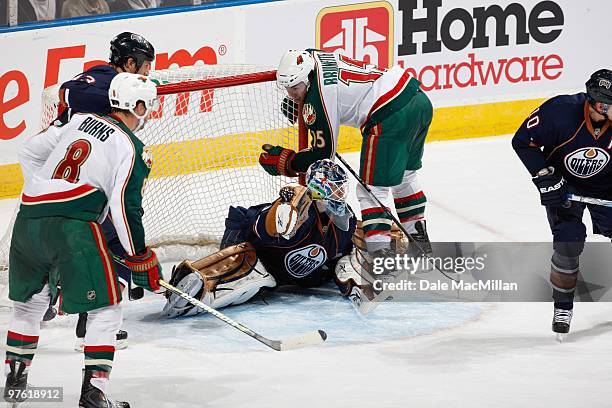 Andrew Brunette of the Minnesota Wild falls on the net and goalie Jeff Deslauriers of the Edmonton Oilers on March 5, 2010 at Rexall Place in...