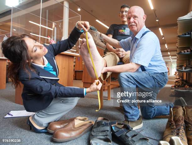 Guinness World Records judge Lucia Sinigagliesi and Georg Wessels of the oversized shoe making workshop Wessels measure the length of the right foot...
