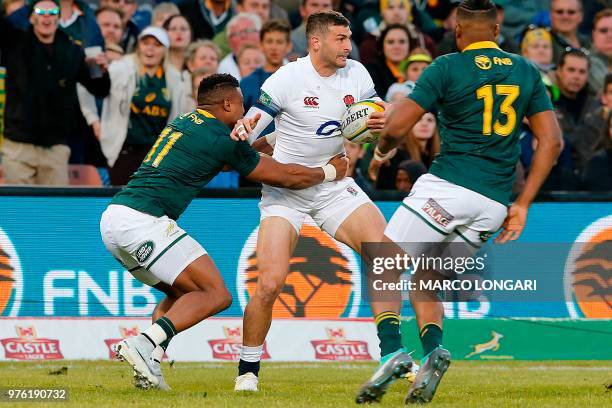 England's wing Jonny May is tackled by South Africa's centre Aphiwe Dyantyi as South Africa's wing Lukhanyo Am looks on during the second test match...