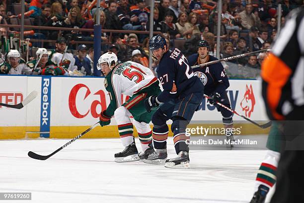 James Sheppard of the Minnesota Wild handles the puck against Dustin Penner of the Edmonton Oilers on March 5, 2010 at Rexall Place in Edmonton,...