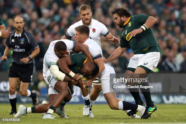 Aphiwe Dyantyi of South Africa is held in the tackle by England's Owen Farrell and Kyle Sinckler during the second test match between South Africa...