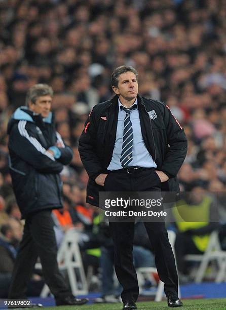 Olympique Lyonnais manager Claude Puel watches his team play Real Madrid beside Real manager Manuel Pellegrini during the UEFA Champions League round...