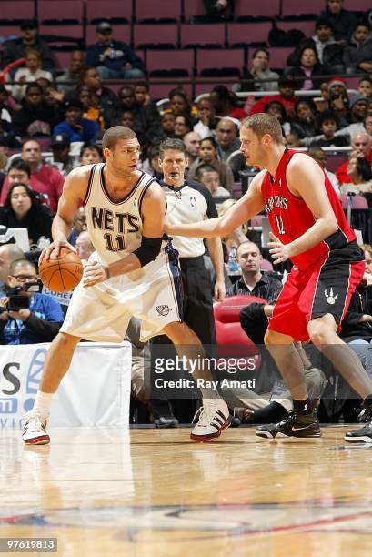 Brook Lopez of the New Jersey Nets handles the ball against Rasho Nesterovic of the Toronto Raptors during the game on February 19, 2010 at the Izod...