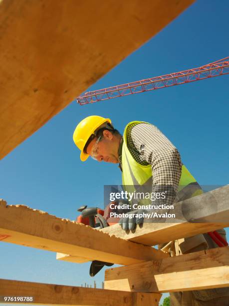 Man planing wood on construction site.