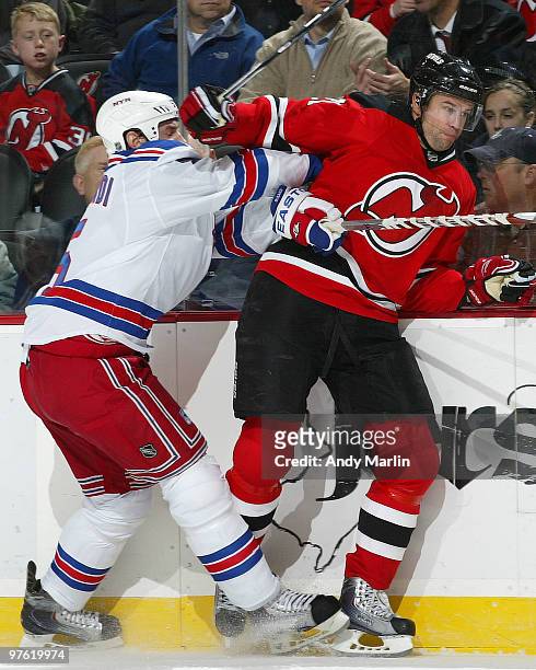 Rob Niedermayer of the New Jersey Devils is knocked hard into the boards by Dan Girardi of the New York Rangers during the game at the Prudential...