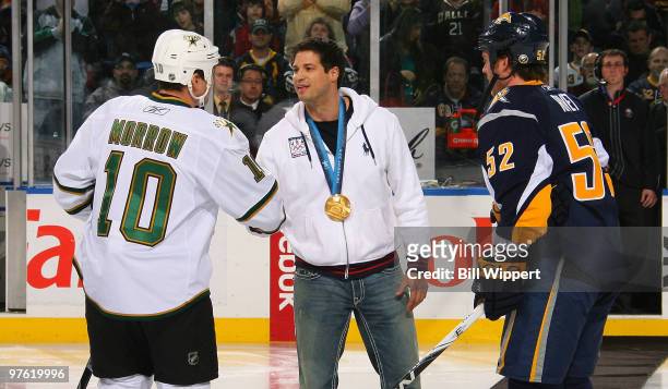 Steve Mesler , a Buffalo native and winner of a gold medal in the four-man bobsled at the 2010 Winter Olympics, drops a ceremonial puck between Craig...