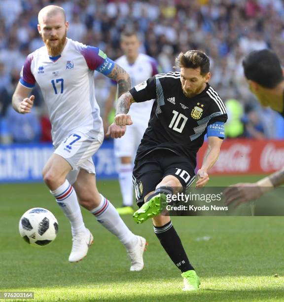 Lionel Messi of Argentina takes a shot near Aron Gunnarsson of Iceland during the first half of a football World Cup group stage match at Spartak...