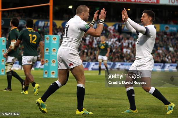 Mike Brown of England celebrates with team mate Ben Youngs after he scores the opening try during the second test match between South Africa and...