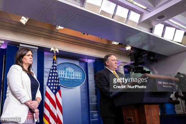 White House Press Secretary Sarah Huckabee Sanders stands by, as U.S. Secretary of State Mike Pompeo speaks to reporters during a briefing in the...