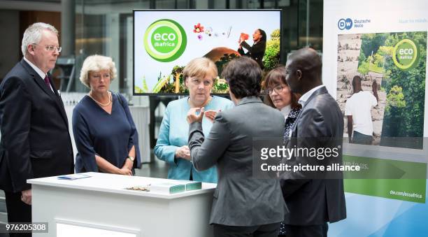 June 2018, Germany, Berlin: German Chancellor Angela Merkel of the Christian Democratic Union informs herself about the work of the channel together...