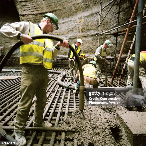 Compacting in situ reinforced concrete using vibrating pokers.