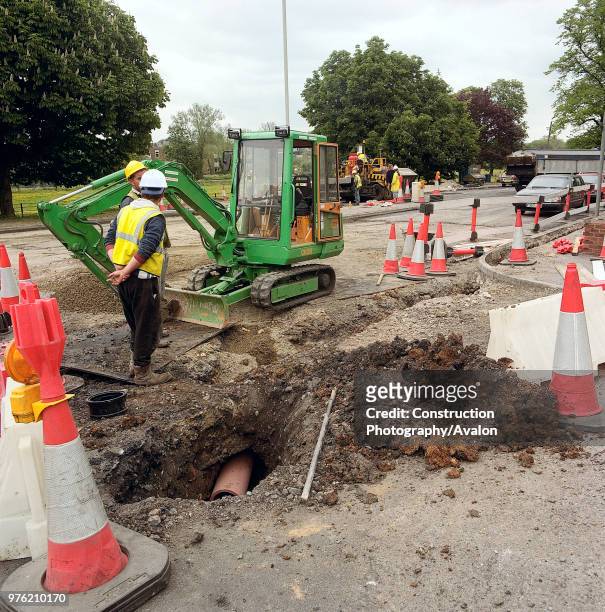 Mini excavator alongside pipe trench in carriageway with temporary road closure, A4251 Hemel Hempstead to Berkhamsted road refurbishment scheme,...