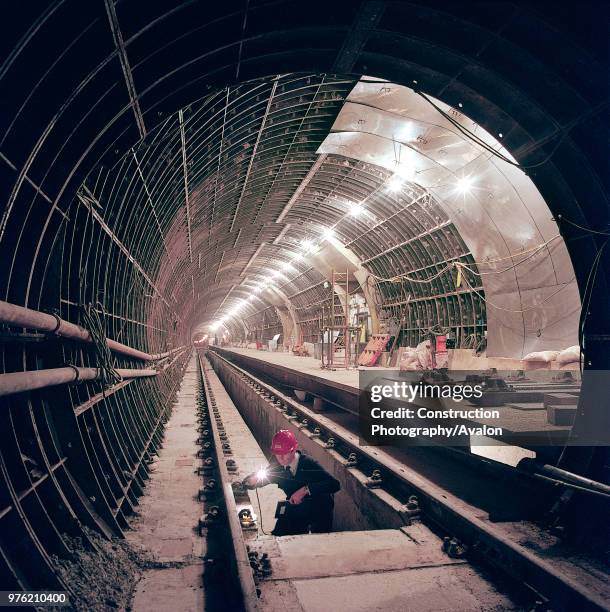 Engineer inspecting rail installation in the new tunnel and platform area of Angel Station. London, United Kingdom, 27th November 2002.