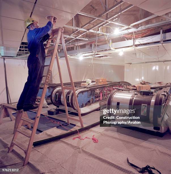 IInstalling suspended ceiling panels during refurbishment of Angel Underground station, London, United Kingdom,.