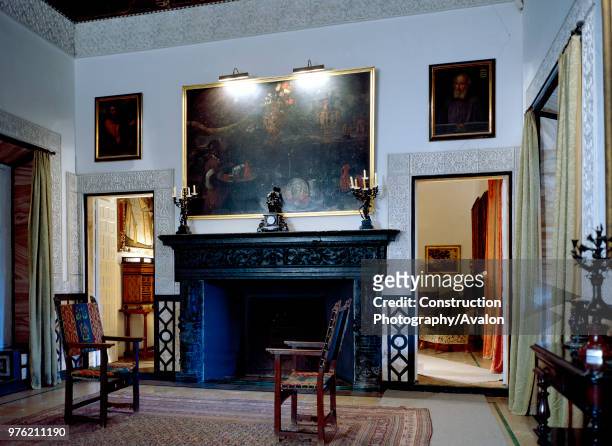Fireplace in living room with chairs and adjoining room, Casa Pilatos, Seville, Spain.