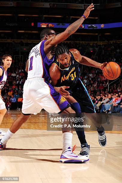 Nene of the Denver Nuggets drives to the basket against Amar'e Stoudemire of the Phoenix Suns during the game at U.S. Airways Center on March 01,...