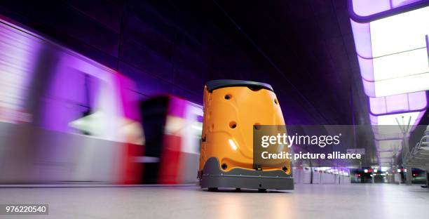 June 2018, Germany, Hamburg: An autonomous cleaning robot called 'Taski Swingobot 2000' is in front of a departing train at the U-Bahn...