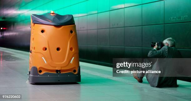 Dpatop - 05 June 2018, Germany, Hamburg: A man takes a picture of the autonomous cleaning robot called 'Taski Swingobot 2000' during its presentation...