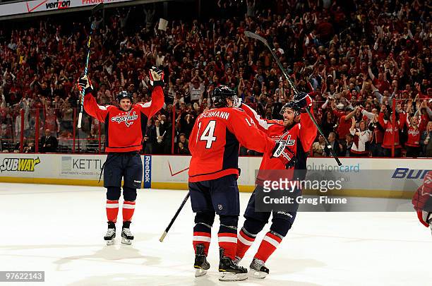 Tomas Fleischmann of the Washington Capitals celebrates with Eric Belanger and Tom Poti after scoring the game winning goal in overtime against the...