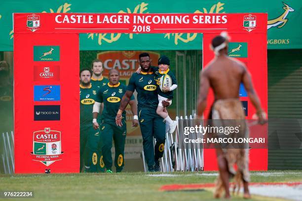 South Africa flanker and captain Siya Kolisi enters the field holding his son Nicholas prior to the second test match South Africa vs England at the...